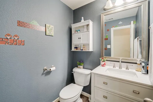a bathroom with a granite countertop toilet sink and mirror