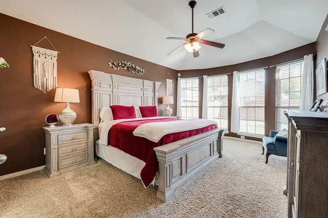 a spacious bedroom with a bed and a chandelier