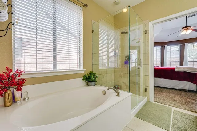 a spacious bathroom with a tub shower and window