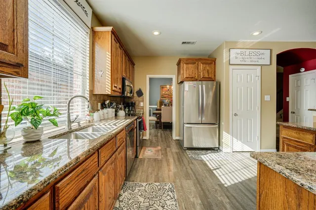 a kitchen with stainless steel appliances granite countertop a refrigerator and a sink