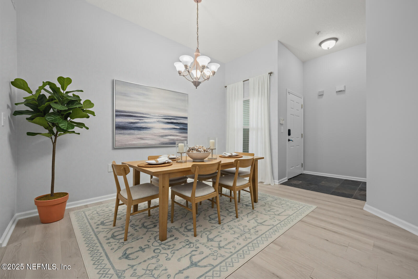 a dining room with furniture potted plants and wooden floor