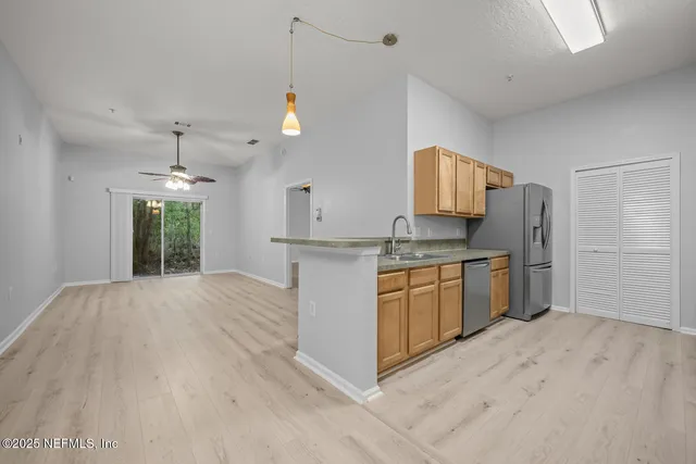 a kitchen with stainless steel appliances granite countertop a sink stove microwave refrigerator and cabinets