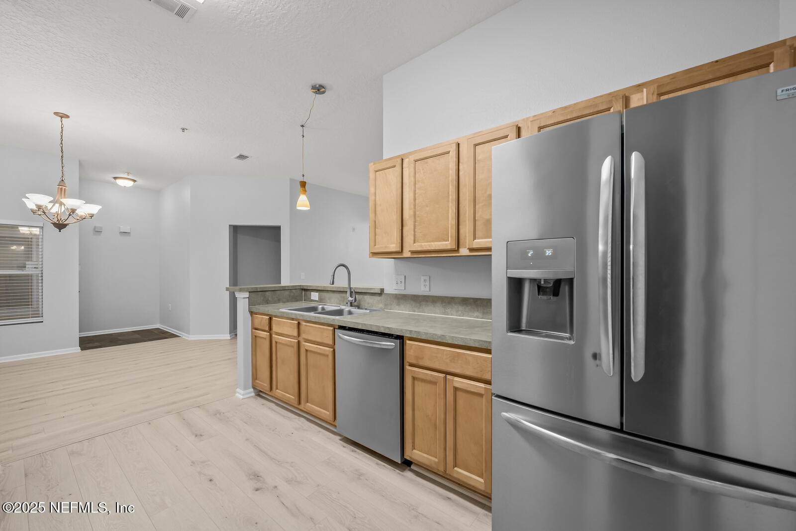 7920 Merrill Road West, Unit 1604 Jacksonville, FL 32277 - Photo 9 of 30 a kitchen with stainless steel appliances granite countertop a refrigerator a sink dishwasher a stove with white cabinets and wooden floor