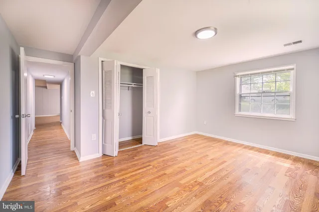 a view of empty room with wooden floor