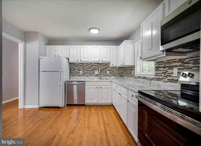 a kitchen with a refrigerator stove and wooden cabinets