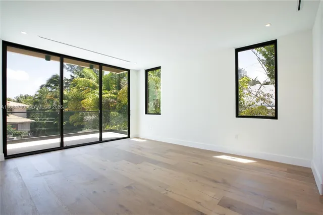 an empty room with sliding glass door and windows