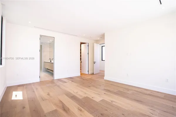 a view of empty room with wooden floor