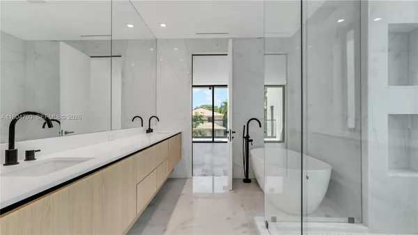 a spacious bathroom with a double sink shower and mirror
