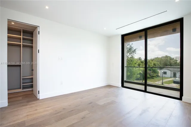 an empty room with wooden floor and sliding door