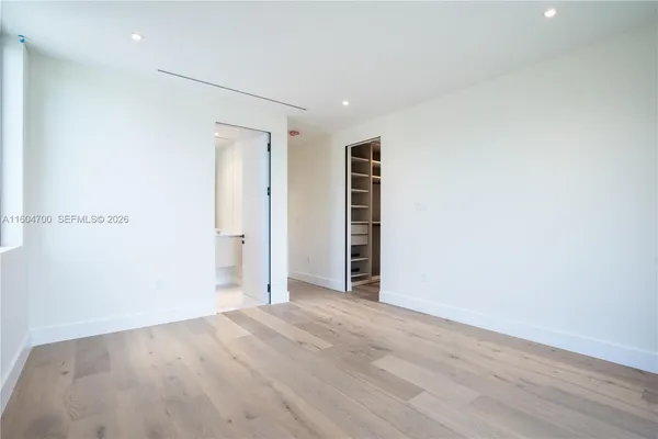 an empty room with wooden floor and closet