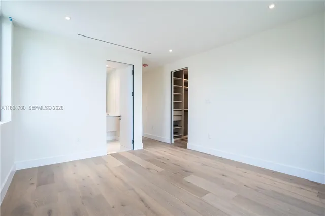 an empty room with wooden floor and closet
