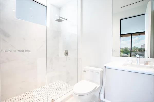 a bathroom with a toilet sink vanity and shower