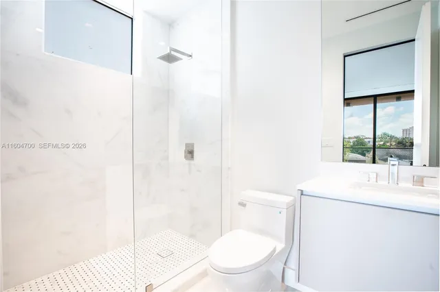 a bathroom with a toilet sink vanity and shower