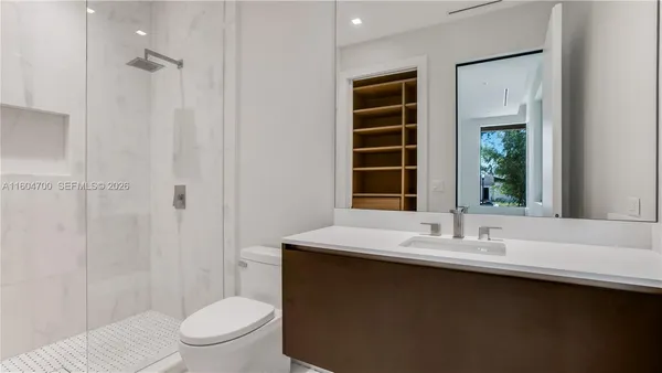 a bathroom with a sink a toilet and shower