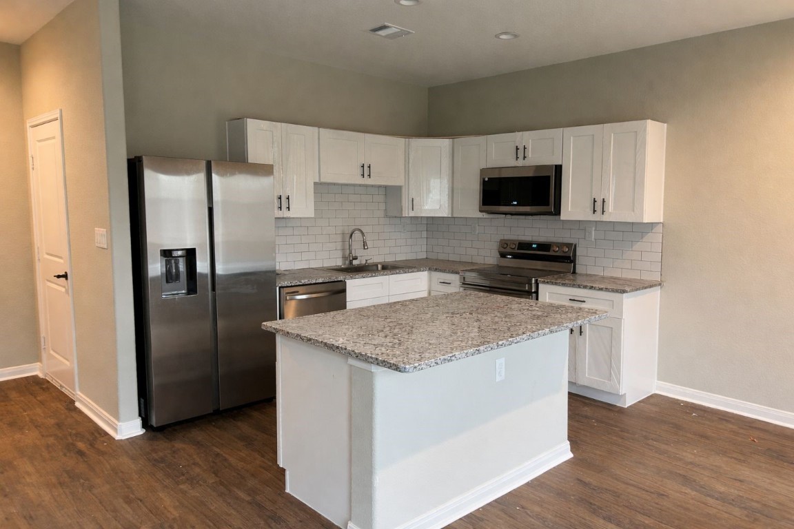 14010 Longstreet Road, Unit 17 Willis, TX 77318 - Photo 9 of 9 a kitchen with stainless steel appliances granite countertop a refrigerator a sink a stove a microwave and wooden cabinets