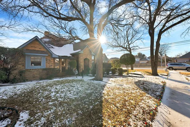 a view of a white house with a yard covered with snow
