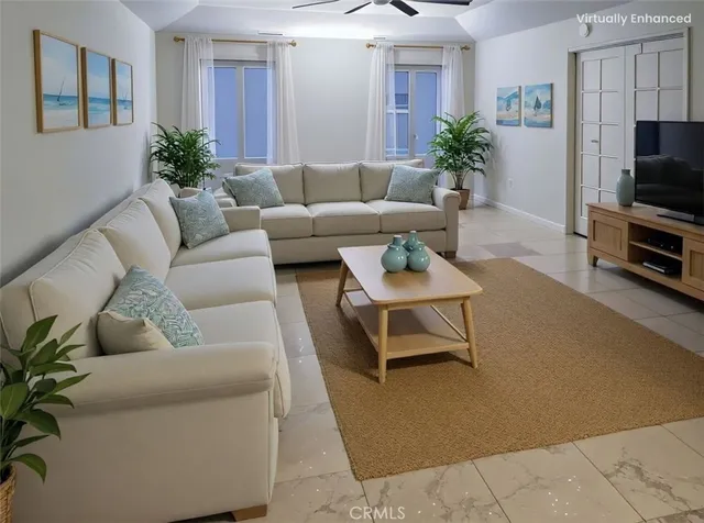 a living room with furniture a flat screen tv and a potted plant