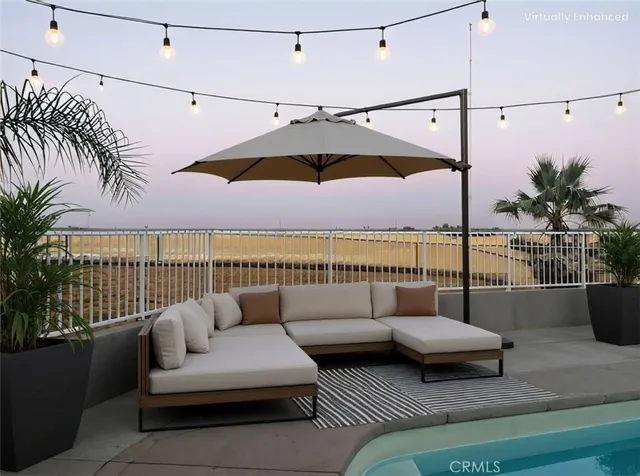a roof deck with couches and potted plants