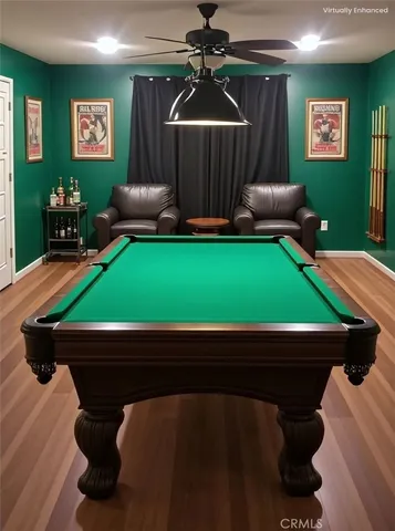 a room with pool table two windows and a chandelier