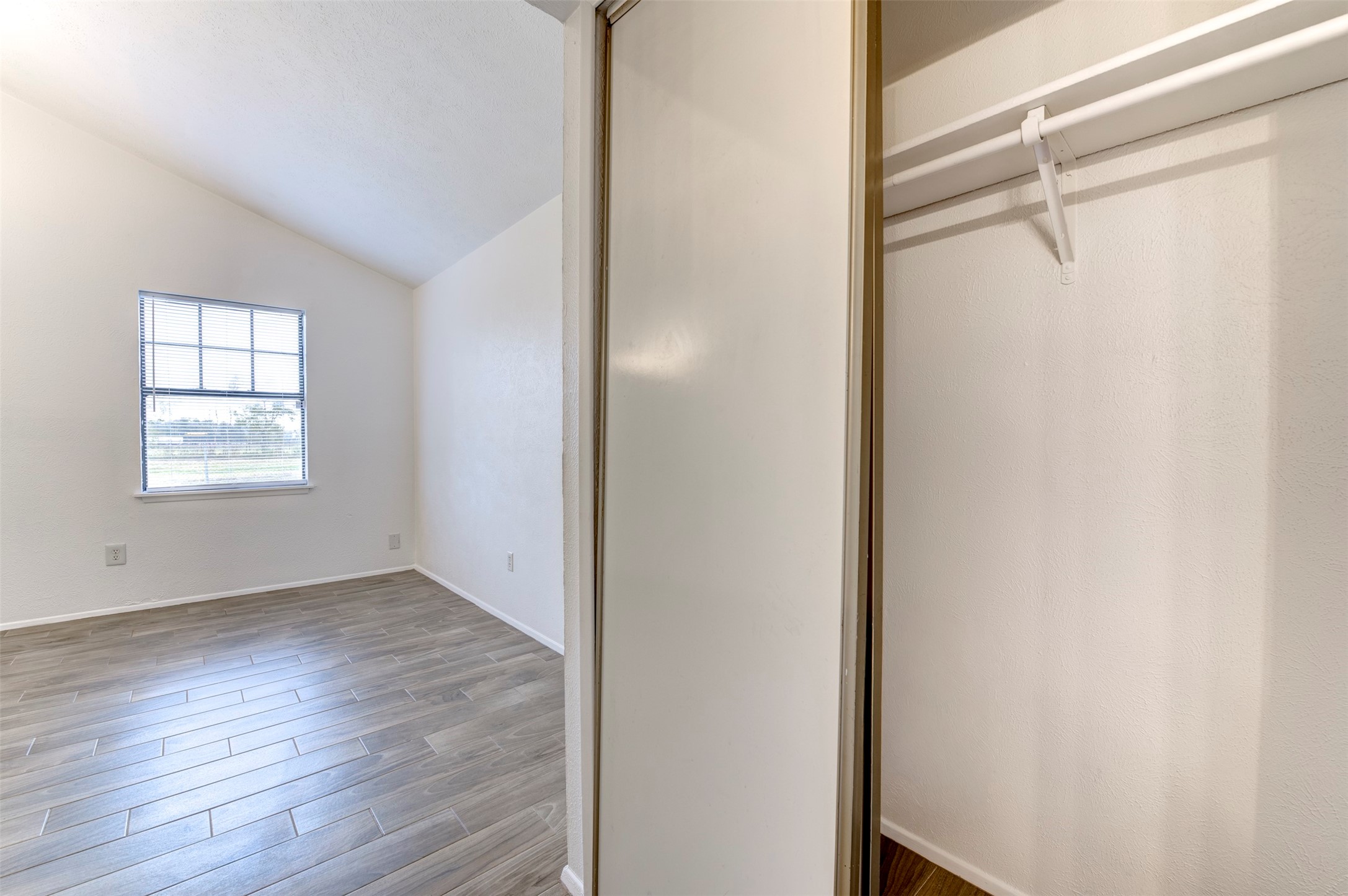 14323 Edenglen Drive Houston, TX 77049 - Photo 18 of 27 a view of an empty room with wooden floor and a window