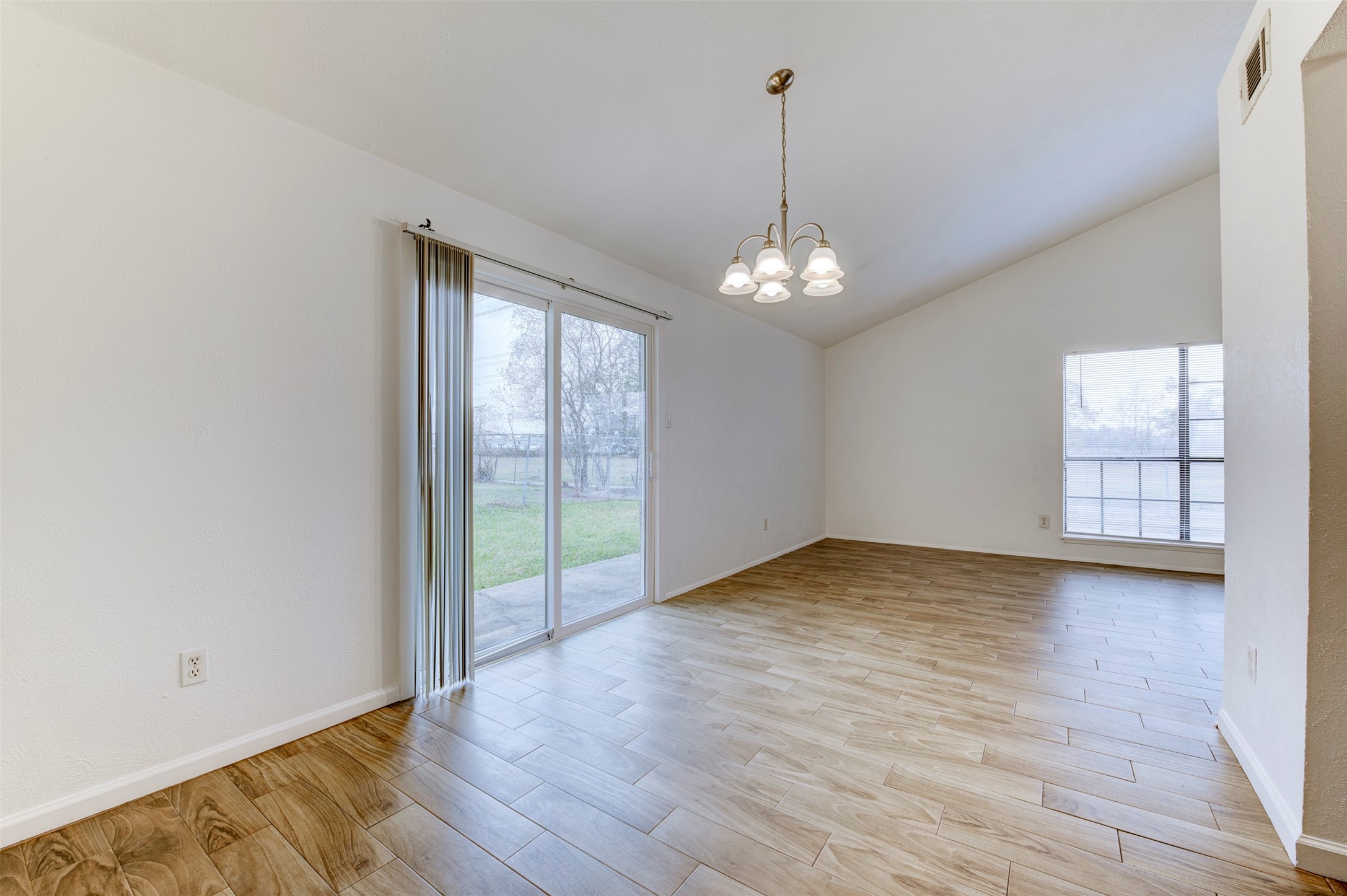 14323 Edenglen Drive Houston, TX 77049 - Photo 2 of 27 a view of an empty room with wooden floor and a window