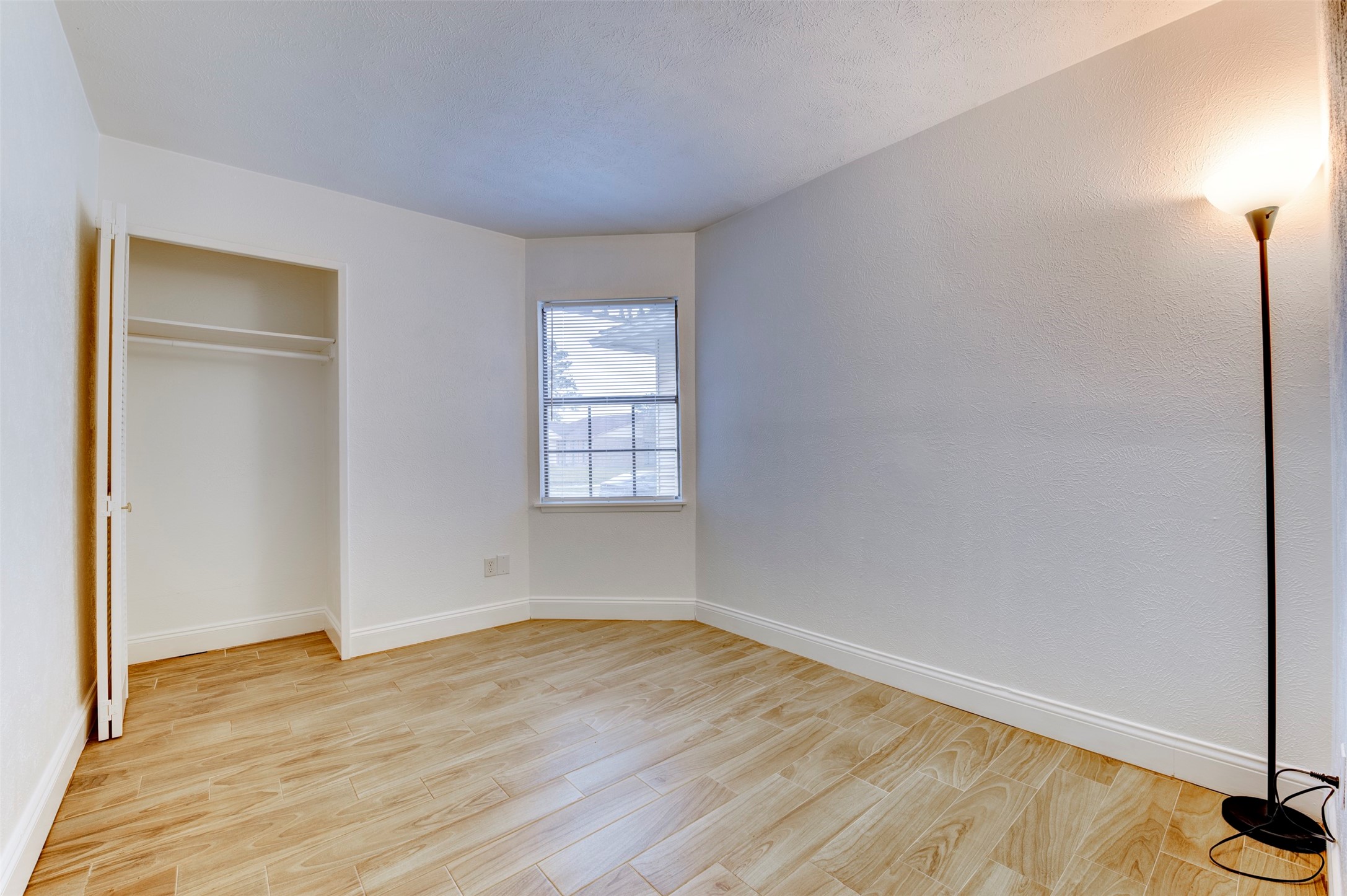 14323 Edenglen Drive Houston, TX 77049 - Photo 23 of 27 an empty room with wooden floor and windows