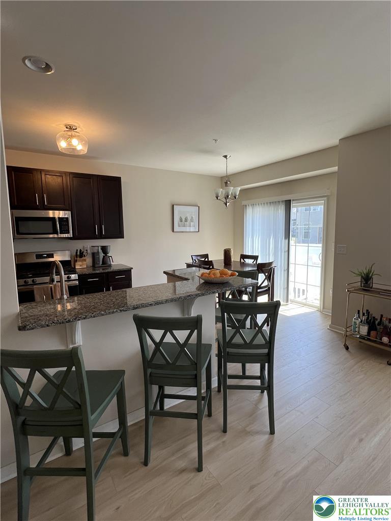 5380 Jutland Road Allentown, PA 18104 - Photo 8 of 27 A functional kitchen island with granite countertops provides ample seating and a seamless transition to the dining area.