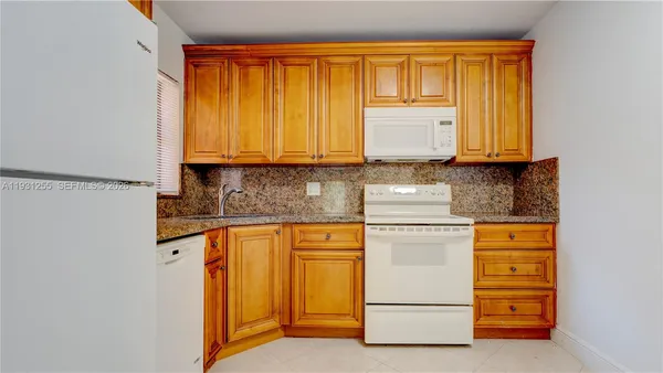 a kitchen with granite countertop cabinets and appliances
