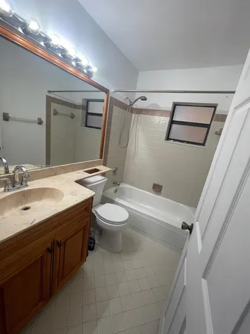 a bathroom with a sink a toilet a mirror and shower