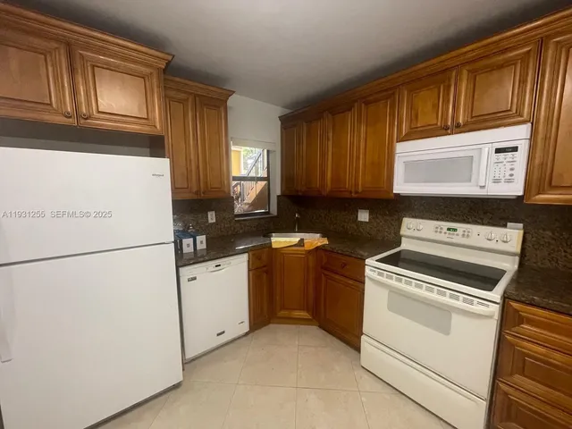 a kitchen with granite countertop cabinets stainless steel appliances and a sink