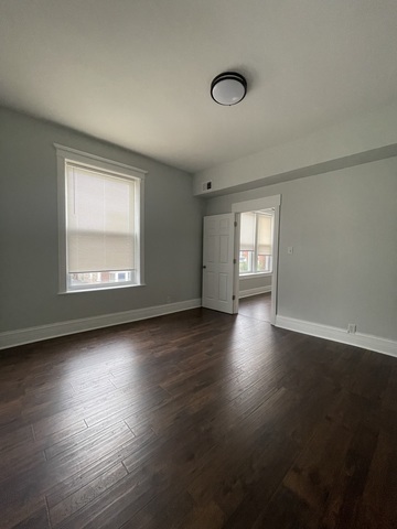 916 West 68th Street, Unit 2W Chicago, IL 60621 - Photo 6 of 8 an empty room with wooden floor and windows