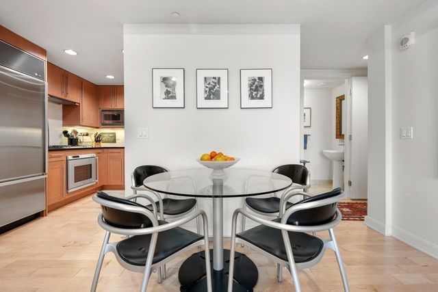 a living room with stainless steel appliances kitchen island granite countertop a stove and a dining table