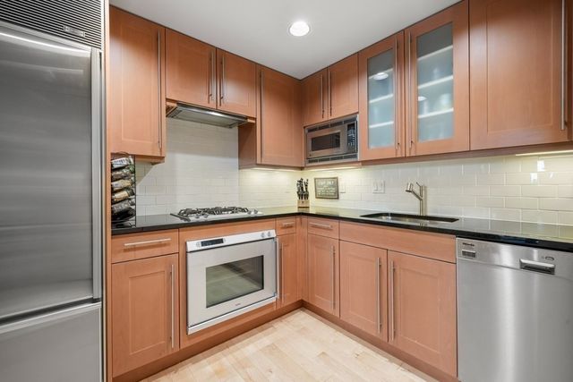 a kitchen with stainless steel appliances granite countertop a stove a sink and a microwave