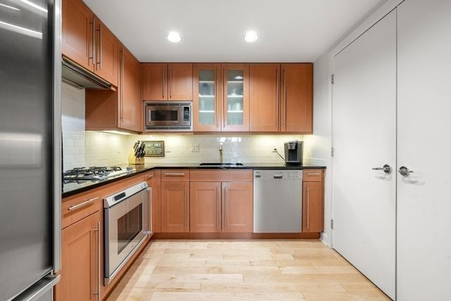 a kitchen with stainless steel appliances granite countertop a stove a sink and a refrigerator