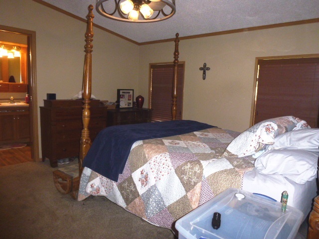 6009 Park Road Clinton, IL 61727 - Photo 5 of 15 a bedroom with a bed and a chandelier