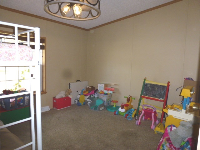 6009 Park Road Clinton, IL 61727 - Photo 10 of 15 a bedroom with a bed and a chandelier