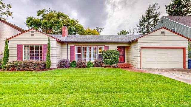 a front view of a house with a garden and yard