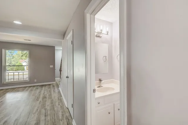 an empty room with wooden floor and a bathroom