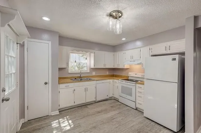 a kitchen with white cabinets and white appliances