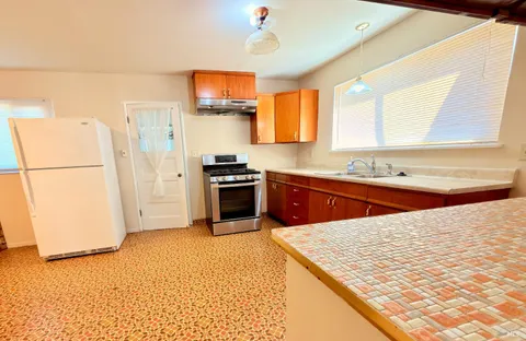 a kitchen with stainless steel appliances granite countertop a refrigerator and a stove