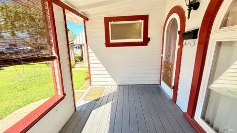 a view of a balcony with wooden floor and door