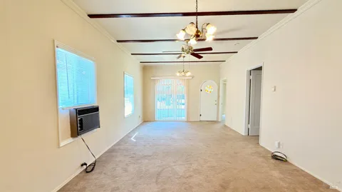 a view of a hallway with wooden floor and chandelier