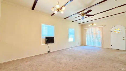 en empty room with windows and ceiling fan