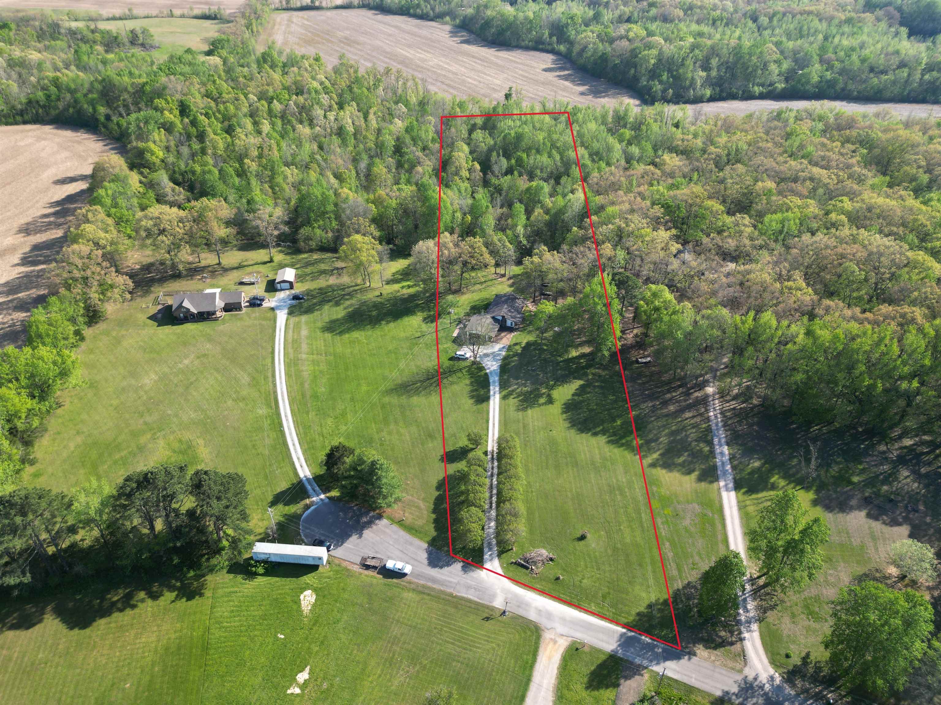 1230 Joann Road Somerville, TN 38068 - Photo 2 of 29 Expansive rural property featuring a long gravel driveway, a single-story residence, and mature tree lines