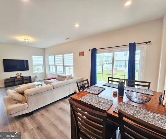 a large kitchen with stainless steel appliances kitchen island granite countertop a stove a sink dishwasher and a refrigerator with wooden floor