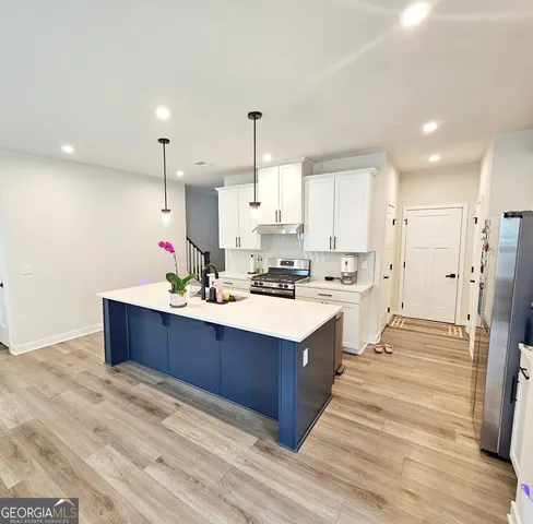 a kitchen with a sink a stove and chairs