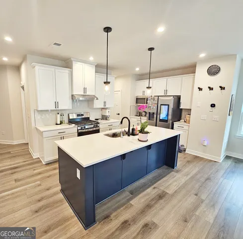 a kitchen with stainless steel appliances a refrigerator stove and sink