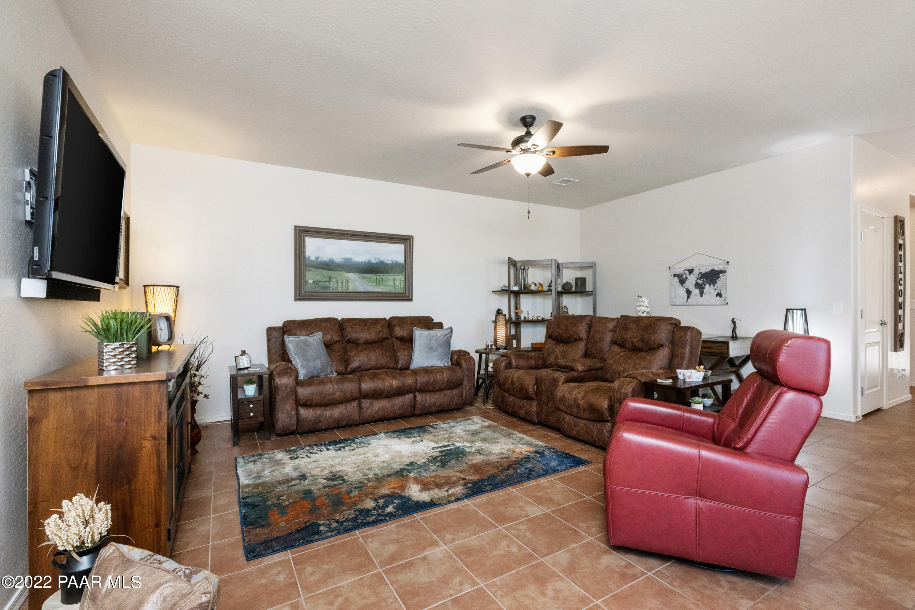 7226 Woolsey Ranch Road Prescott Valley, AZ 86314 - Photo 6 of 30 a living room with furniture a flat screen tv and a chandelier