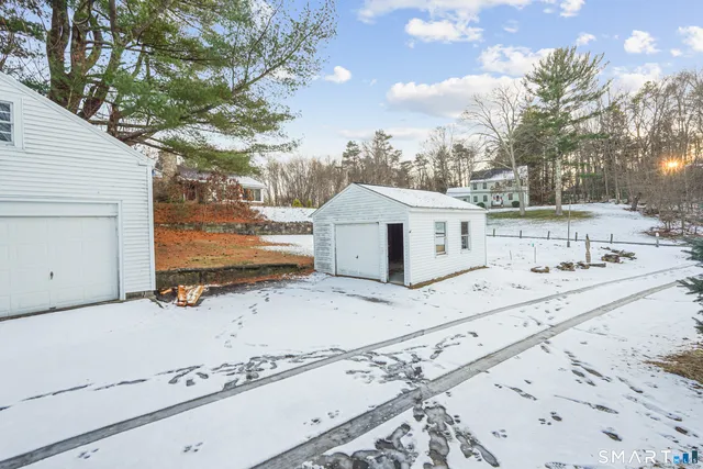 a view of a white house that has a tree in it