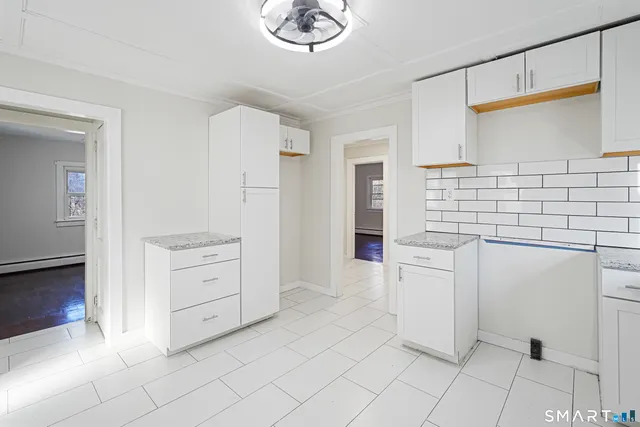 a kitchen with white cabinets and white appliances